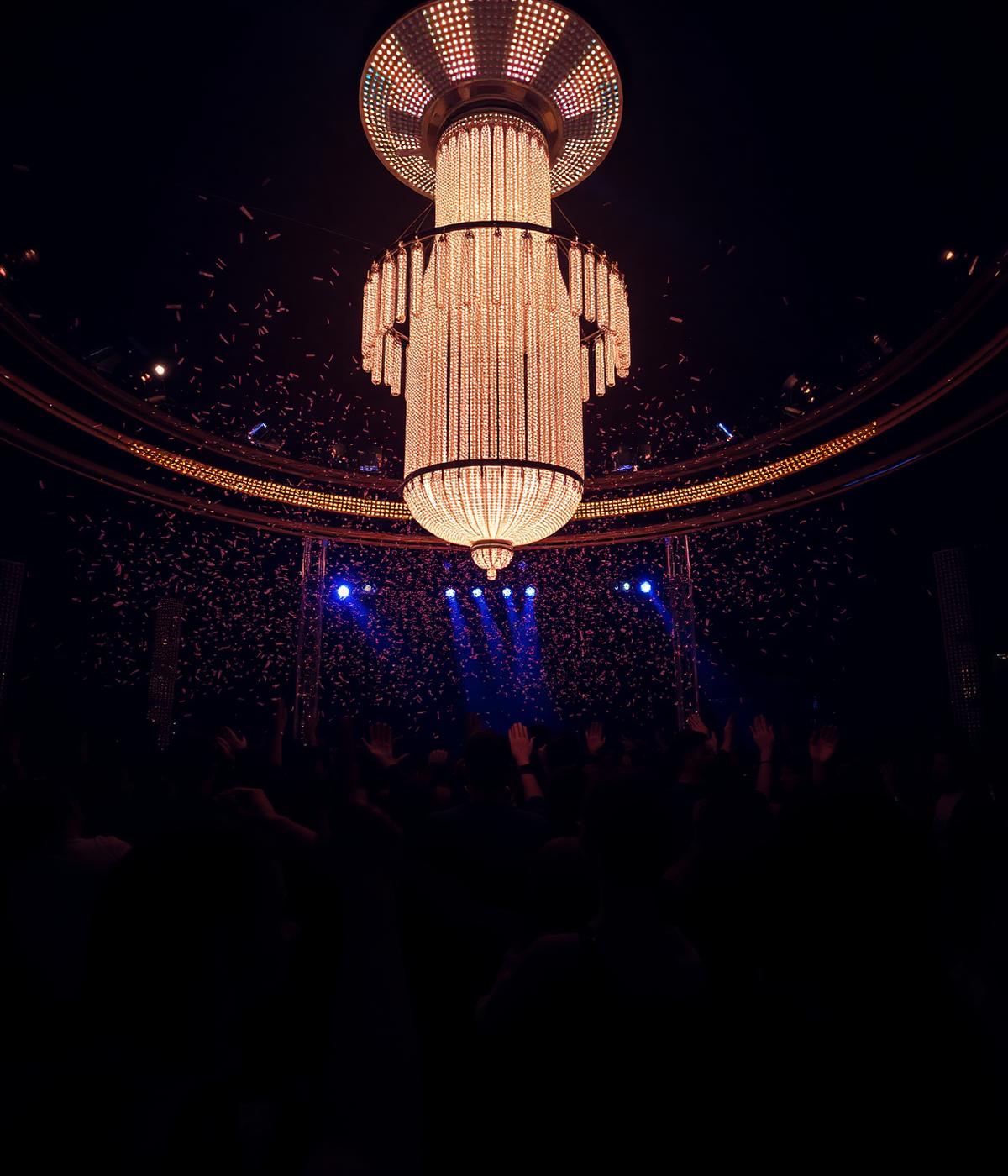 Nightclub chandelier above a crowd with confetti